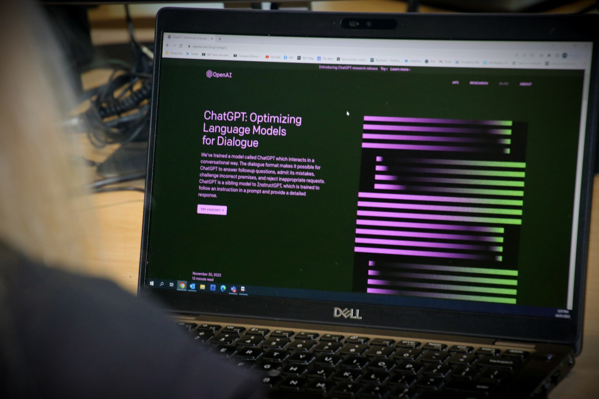 一位女士坐在电脑前，屏幕上显示着紫色和绿色